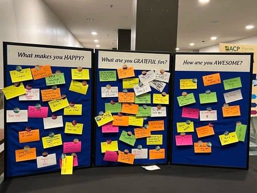 Un panel de bienestar cubierto de notas escritas a mano sobre la felicidad y la gratitud