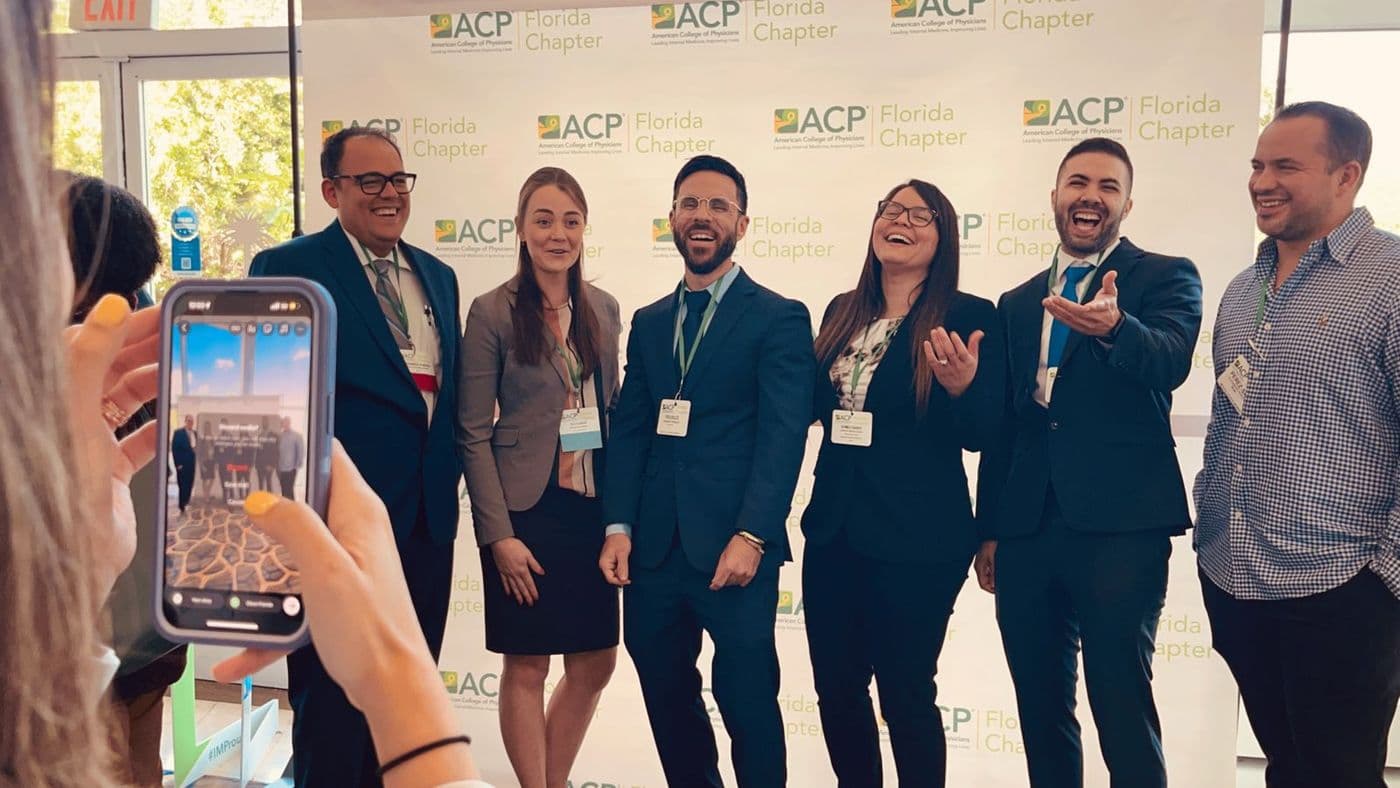 Miembros posando juntos frente al fondo del Capítulo de Florida del ACP